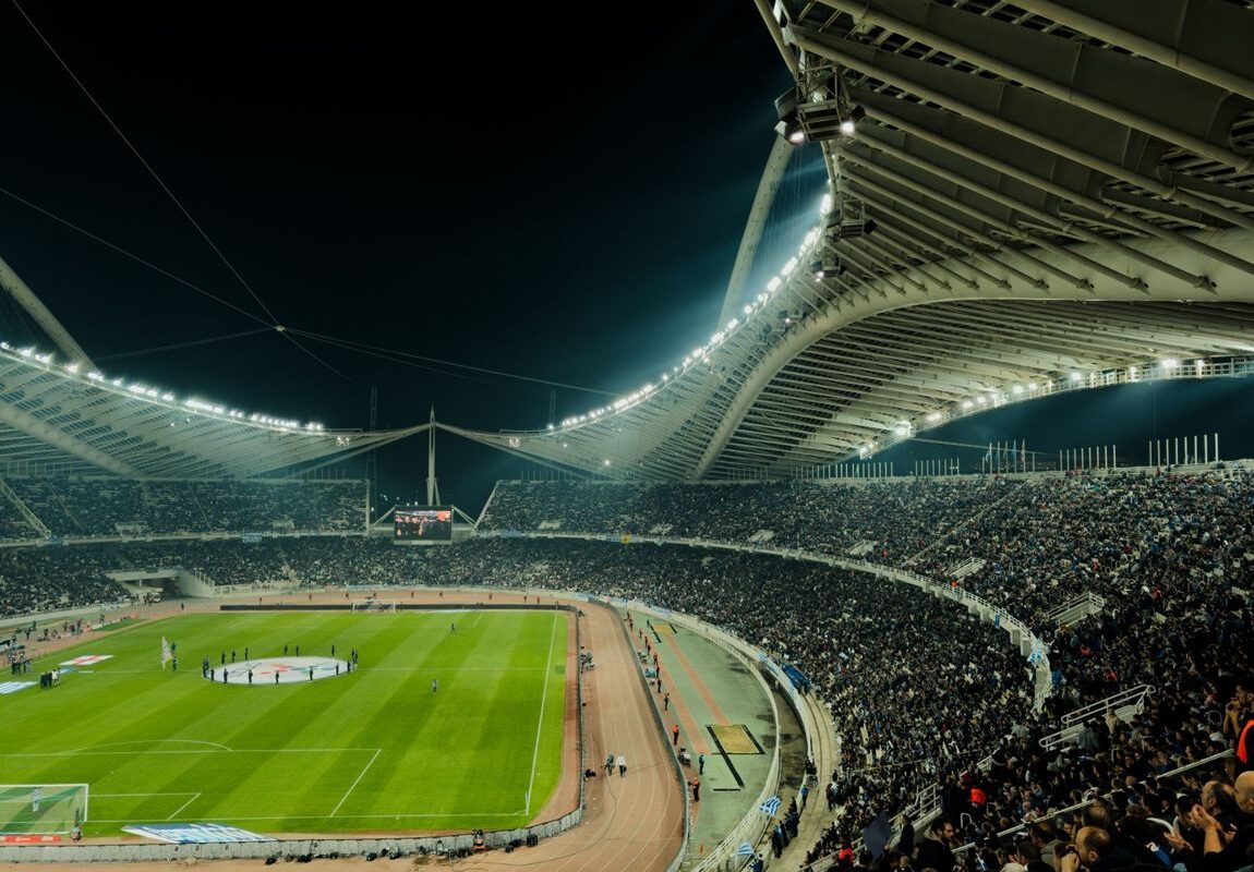 Packed stadium at night under the floodlights